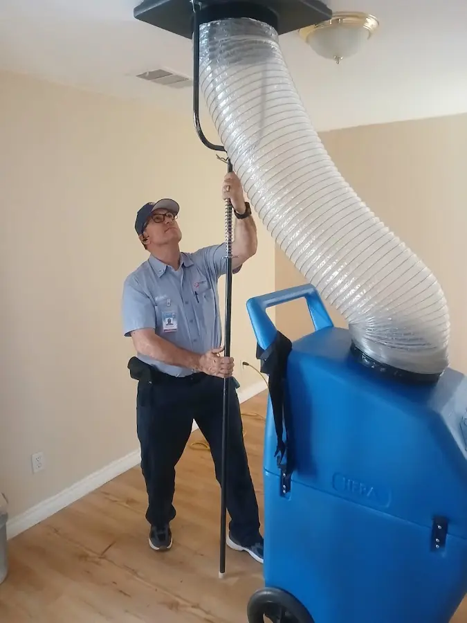 Furnace Tune-Up technician using HEPA equipment in Travis Ranch